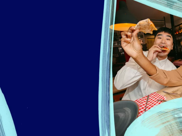 A couple of friends are taking a selfie of having pizza together.